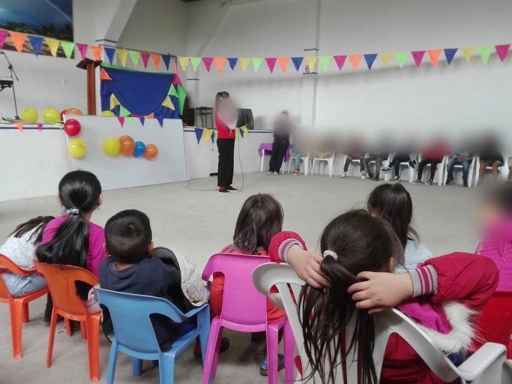 Niños de espaldas sentados en el salón